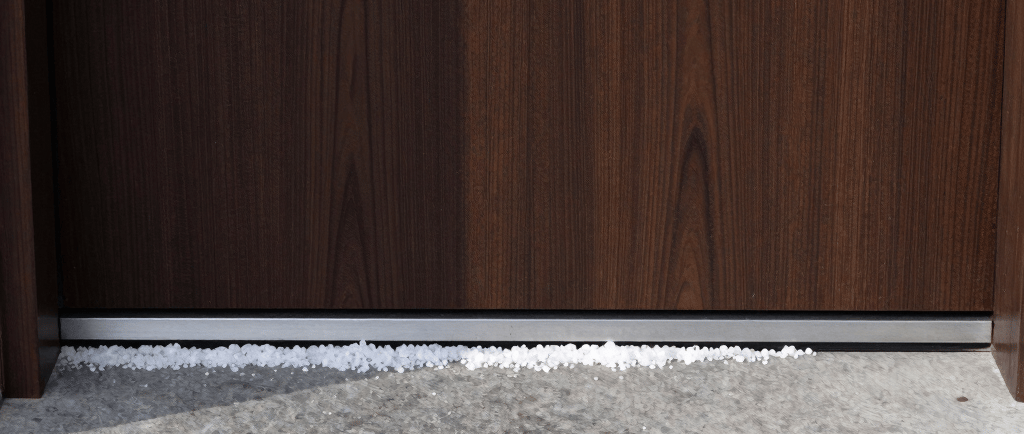 White rock salt spread across a stone doorstep and front door threshold for winter ice melting.