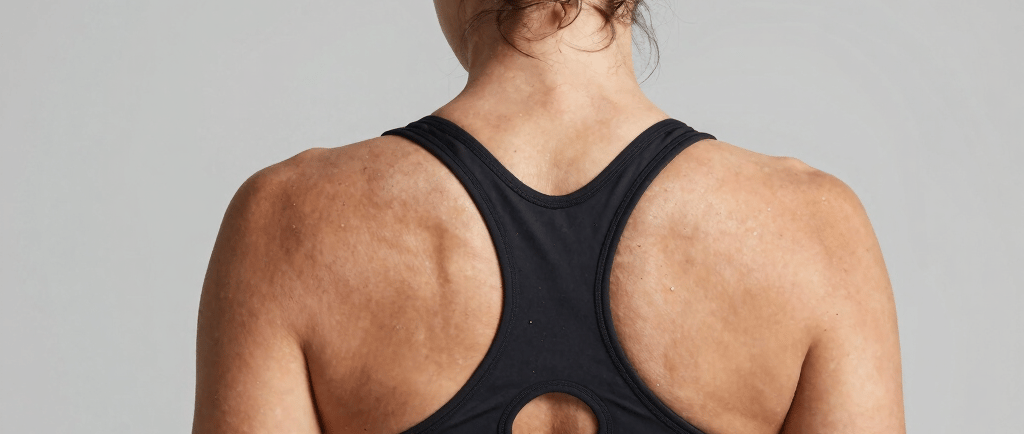 Back view of a woman wearing a black racerback sports bra for athletic fitness and gym workouts.