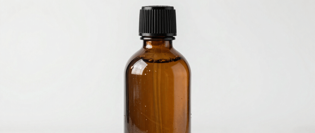 Amber glass dropper bottle with star anise and incense cubes for natural wellness aromatherapy.