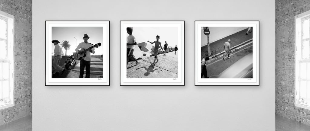 Three framed black-and-white photographs from Martin Osner’s On the Move collection displayed on a gallery wall.
