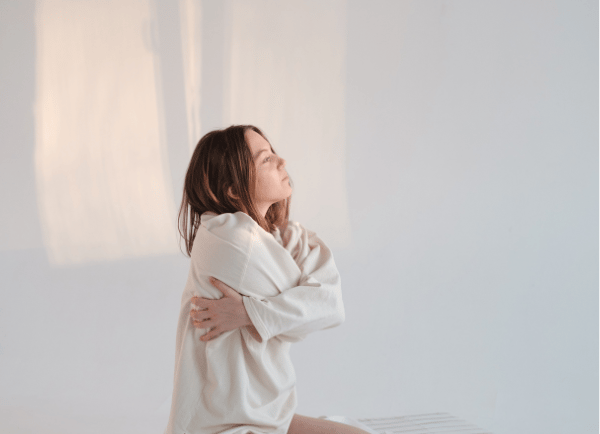 a girl folding her hands around her body