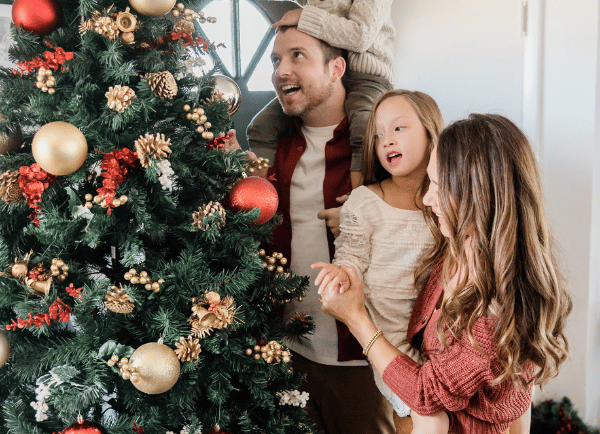 Christmas tree beside a family members standing 