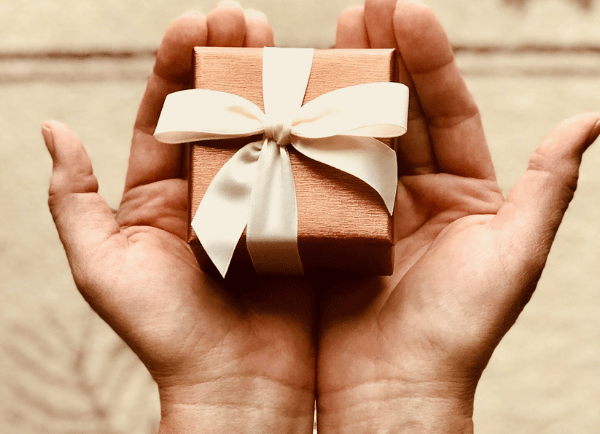 holding a small gift box in  both hands