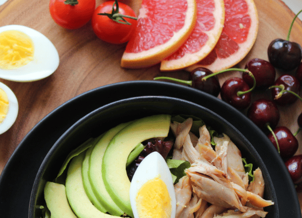 a bowl of fresh vegetables and fruits on table
