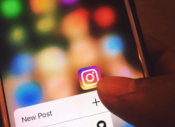 holding a phone which has Instagram logo