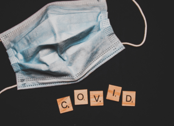 a mask and written covid with cross word 