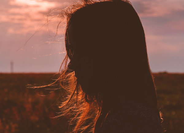 a girl standing in sunset 