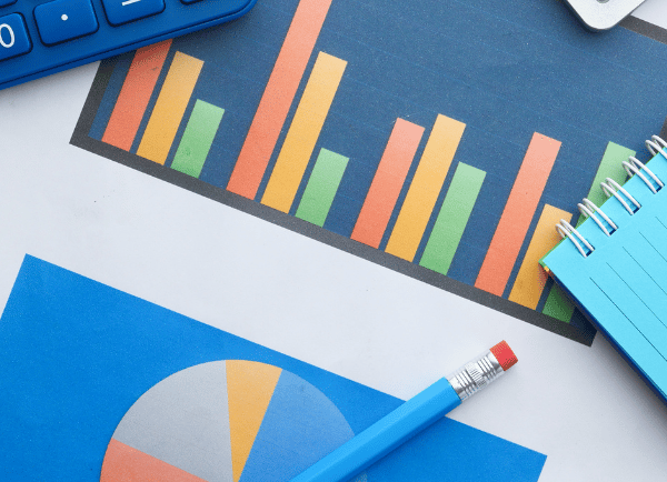 a pencil a calculator a notebook and a chart on the table