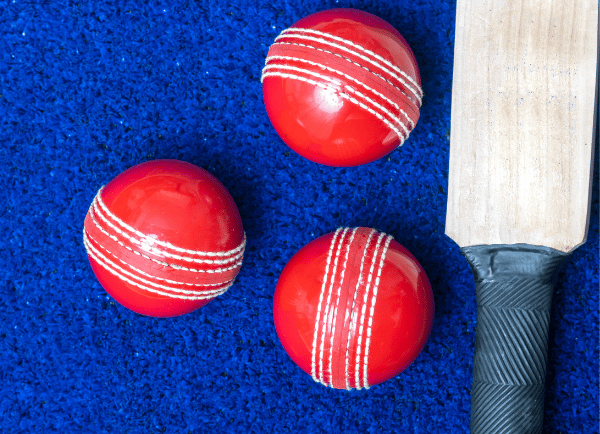 a bat and red colour three balls on blue surface 