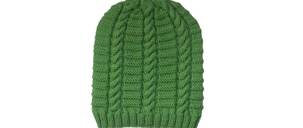 Green knitted ribbed cable beanie pattern on a white background.