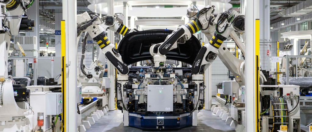 A high-tech automotive manufacturing facility with multiple robotic arms assembling a vehicle.