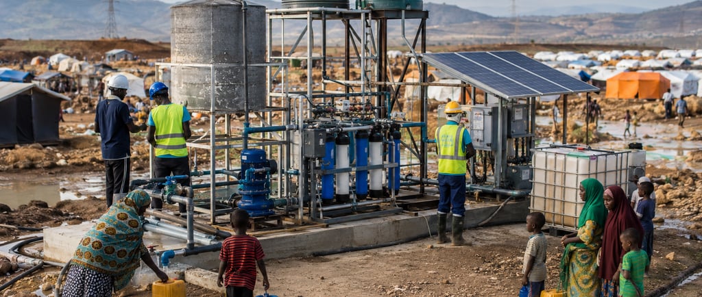 Modular water system made from repurposed metal serving families in a climate migration camp.