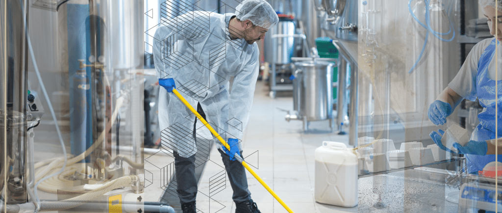 Profissionais trabalhando em ambiente limpo e regulamentado da indústria de alimentos.