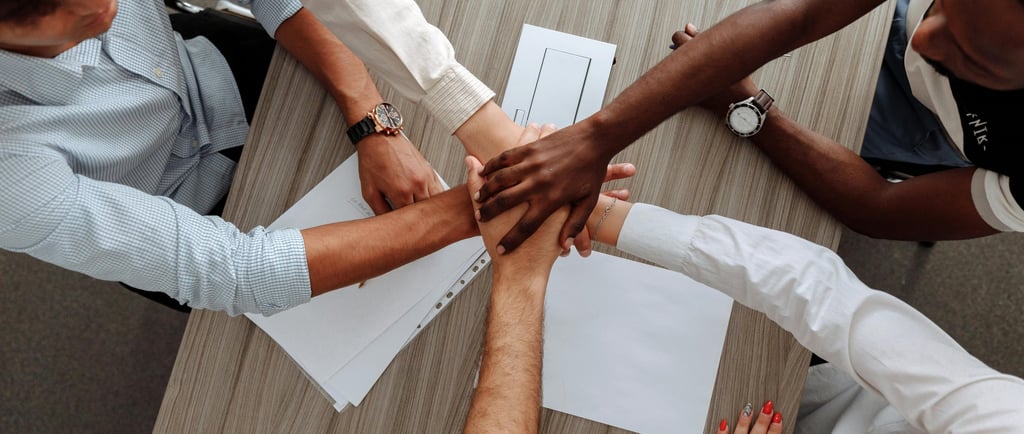 5 people putting their hand up on each other