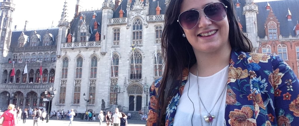 foto da autora na praça do mercado em Bruges