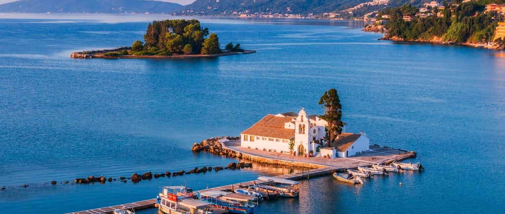 Vista do mar Jônico ao se aproximar de Corfu, com ilhotas e igreja à beira-mar em destaque.