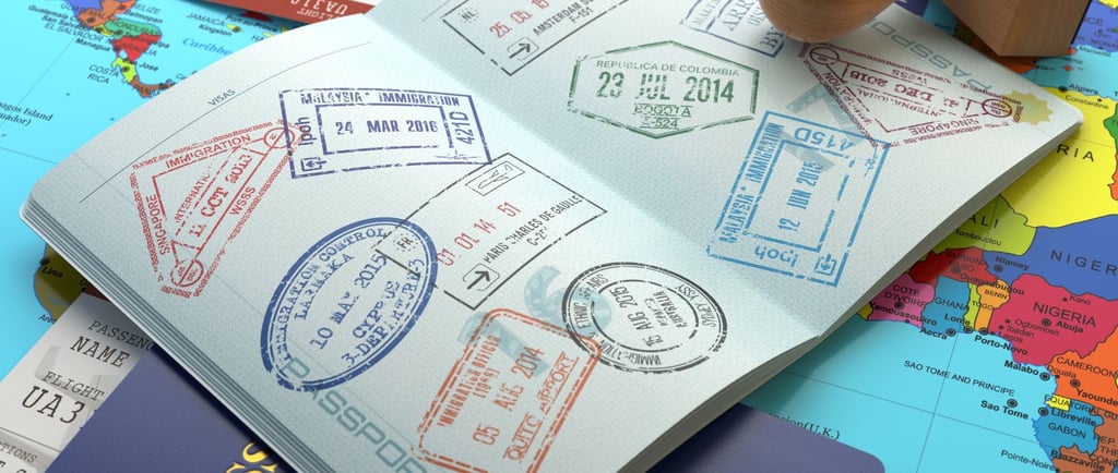 Páginas de passaporte abertas com vistos e carimbos de diferentes países.