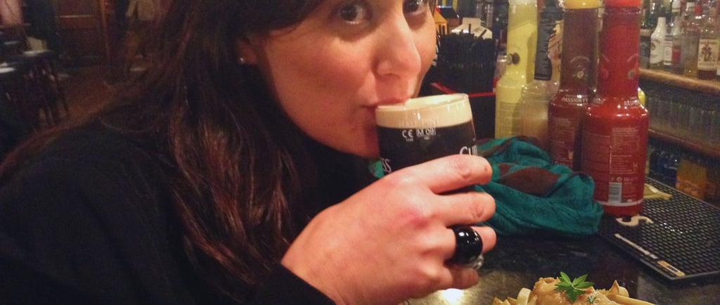 Foto da autora no pub comendo e bebendo em Dublin.