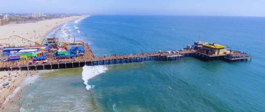 Vista aérea do icônico píer de Santa Monica, Califórnia, com a roda-gigante ao fundo.