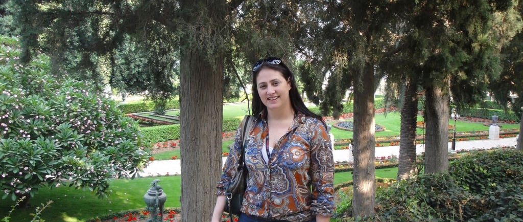 Foto da autora nos jardins em Haifa.