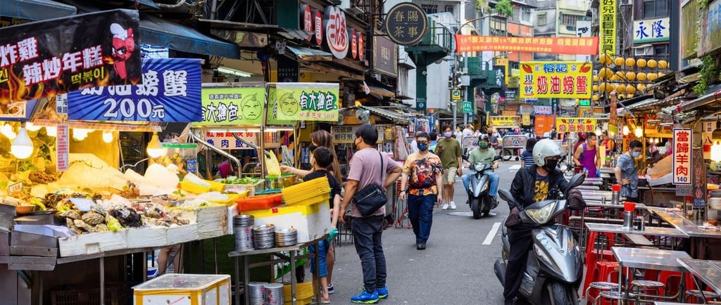 Barracas e movimento do Miaokou Night Market em Keelung, Taiwan.