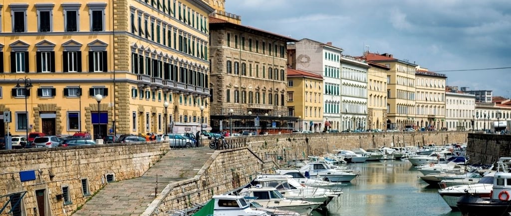 Barcos ancorados nos canais de Livorno, em cenário que lembra Veneza