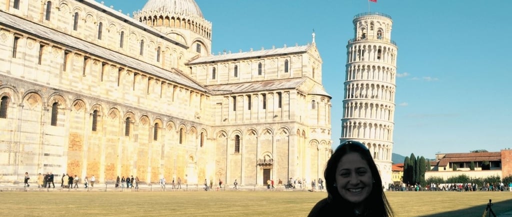 Catedral histórica com torre inclinada ao fundo em cenário ensolarado da Toscana