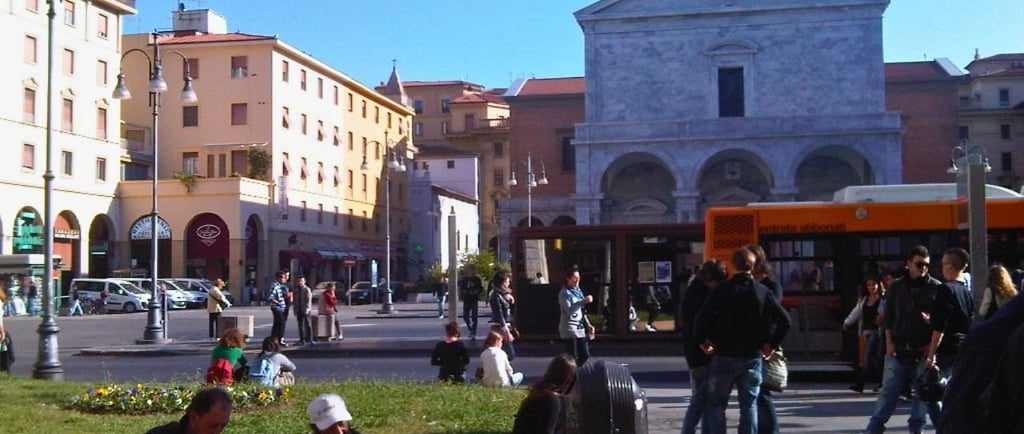 Praça central de Livorno com turistas e atividades ao ar livre.