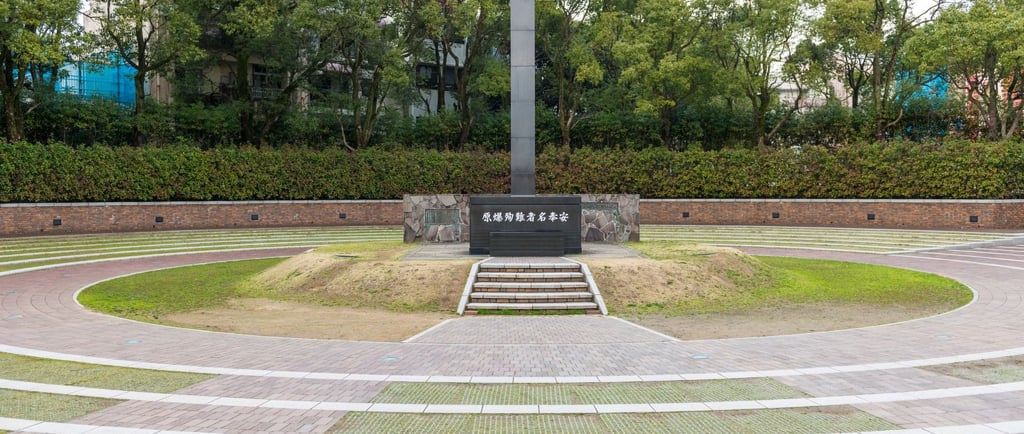 Memorial da Paz de Nagasaki, com estátua central e placas que lembram as vítimas da bomba atômica.