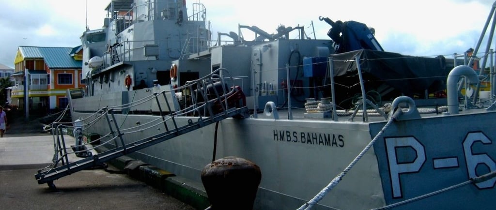 Navio militar ancorado no porto de Nassau garantindo a segurança.
