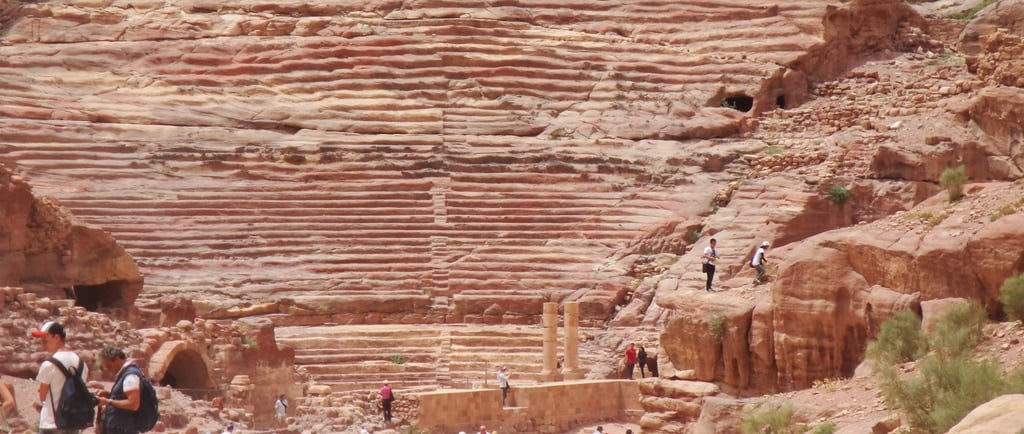 Vista do Anfiteatro de Petra, com as colunas e assentos escavados na rocha ao fundo.