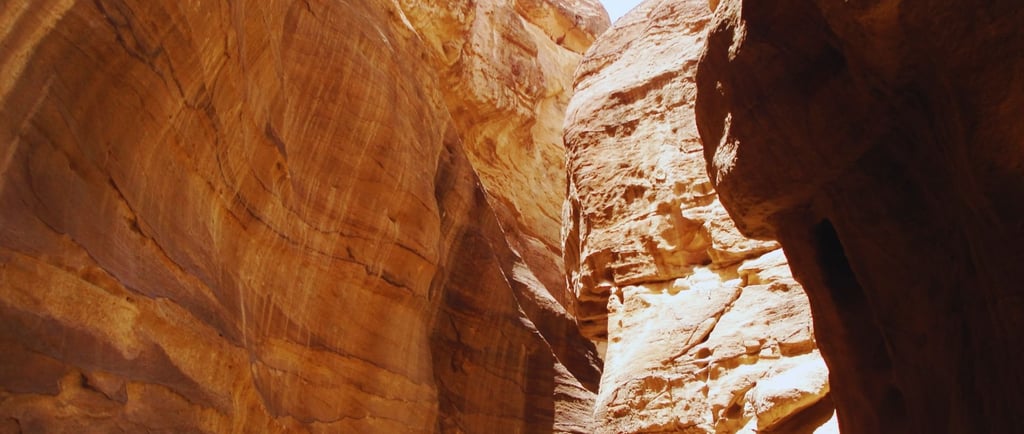 Curvas do Siq em Petra com destaque para os tons avermelhados, alaranjados e rosados.