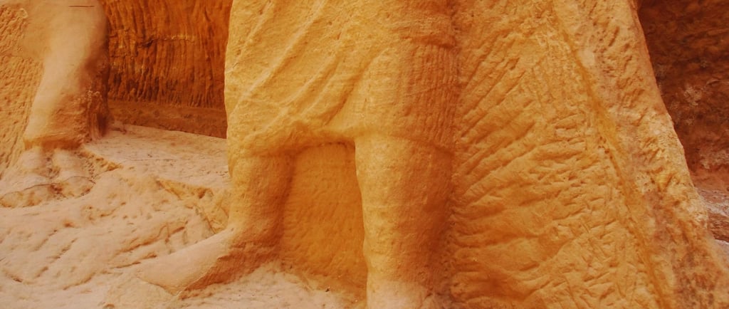 Escultura das pernas esculpidas na rocha em Petra, remanescente de figura monumental.