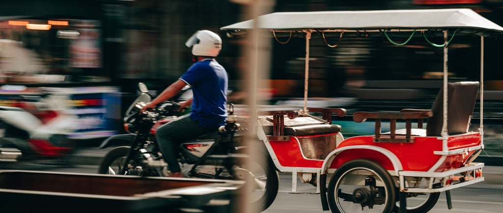 Cena típica do centro de Sihanoukville, com trânsito de bicicletas e tuk-tuks.