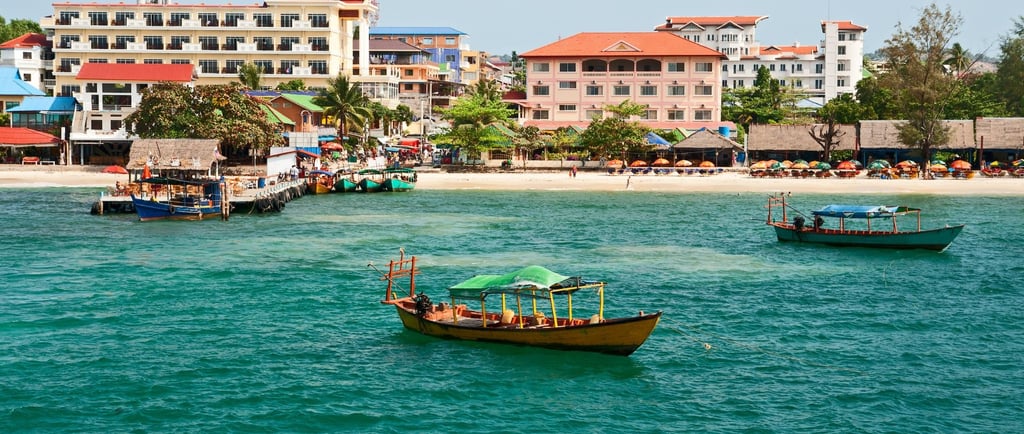 Cidade de Sihanoukville à beira-mar com casas ao fundo.