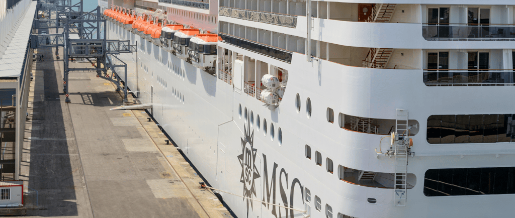 Navio da MSC no porto, destaque para embarque e desembarque em terminal de cruzeiros.