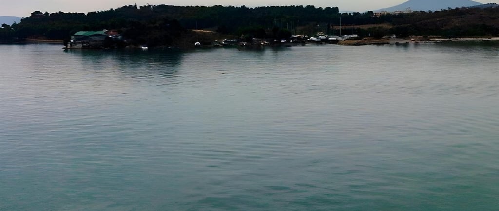 Foto tirada do convés mostrando a cidade de Vólos ao amanhecer, na chegada de navio.