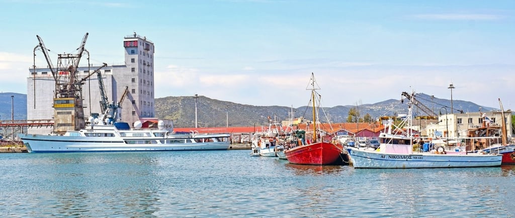 Vista da cidade de Vólos a partir do píer, com barcos ao fundo.