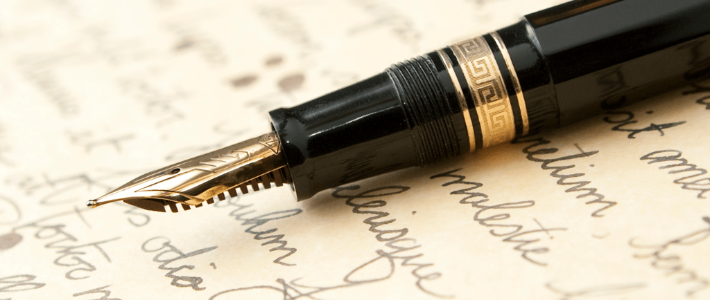 Uma caneta tinteiro sobre uma folha manuscrita