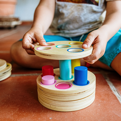 a child's hands holding a wooden toy