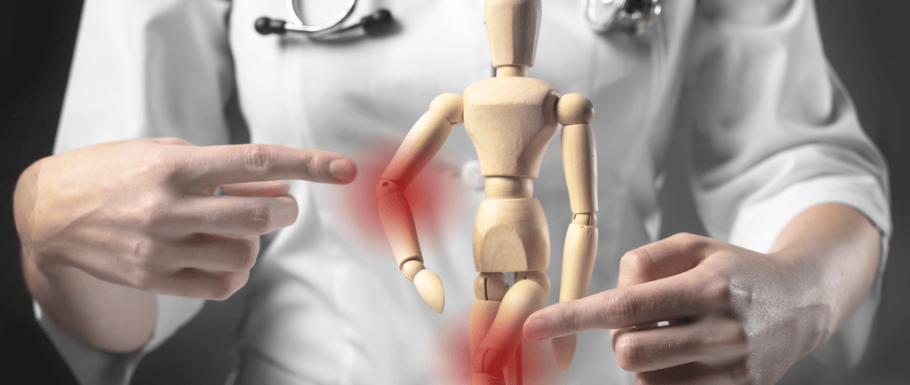 a wooden dummy with a doctor's hand pointing at a person with a red
