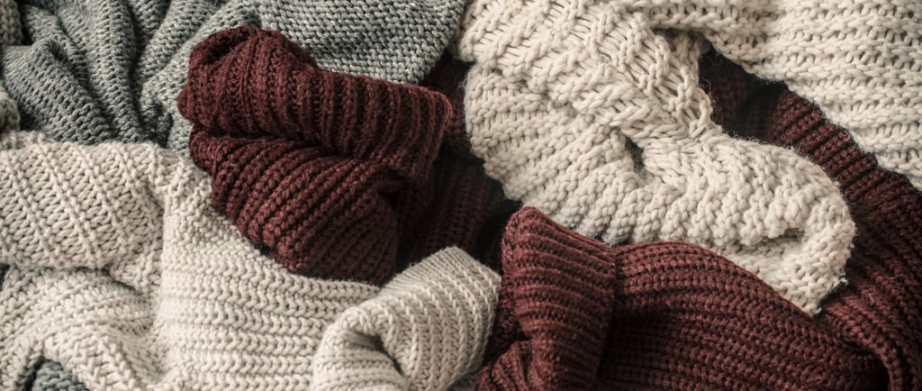 a pile of sweater knitted scarves and other wool materials