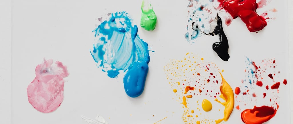 Abstract artistic colorful paint splatters and thick acrylic smears on a white background.