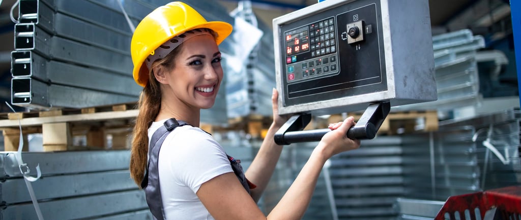 Funcionária de fábrica sorri enquanto opera maquinário.