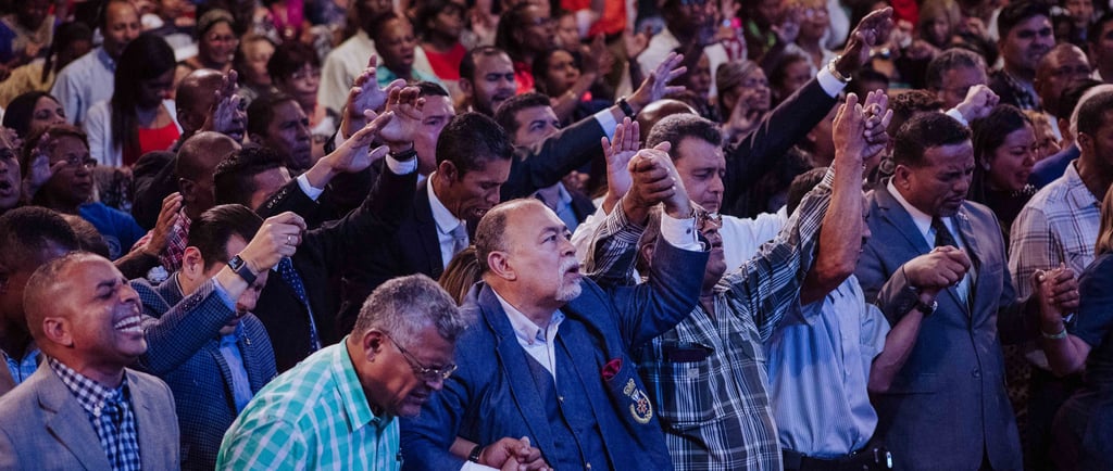 a crowd of people standing and praying