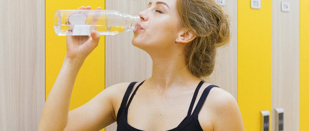 A woman drinking warm water to stay hydrated during the winter season, promoting healthy hydration 