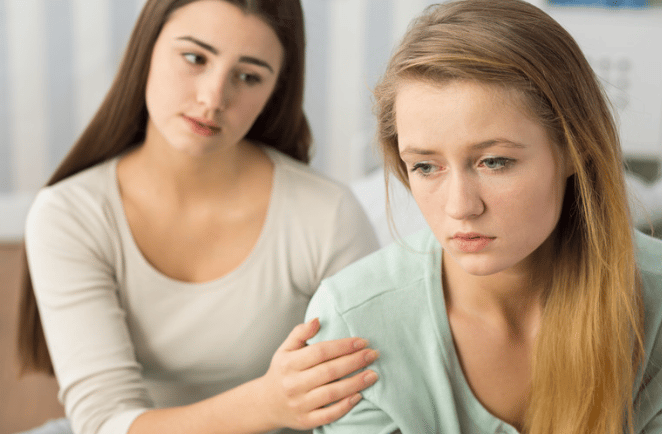 Deux jeunes femmes, l'une semblant éprouver un mal-être, illustrant la blessure d'humiliation