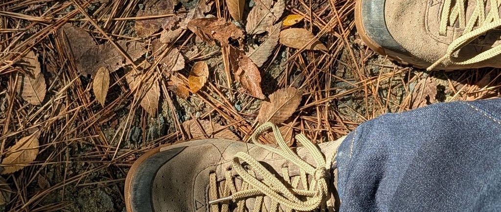 Greg Rowland hikung. Close up photo of his boots.
