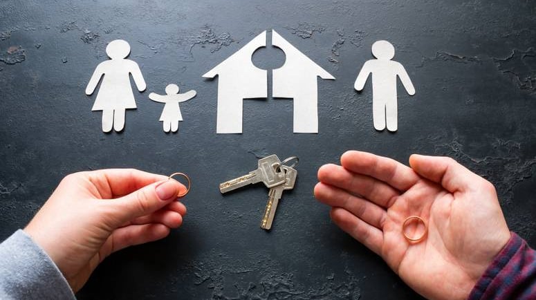 a person holding a keychaik and a house shaped paper cutout of a
