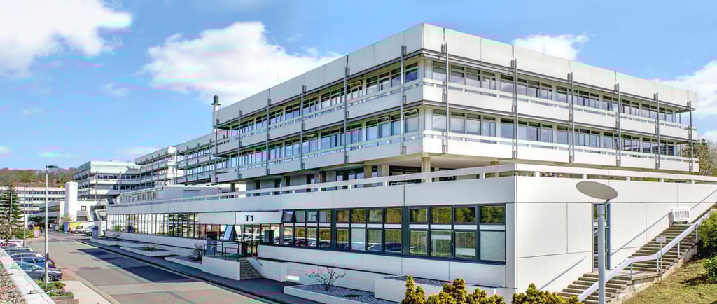 Max Planck Institute building with white exterior and windows, set against a blue sky with scattered